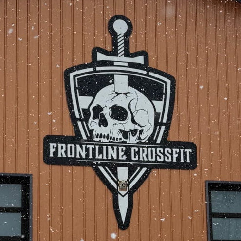 Logo of Frontline CrossFit on a wooden background